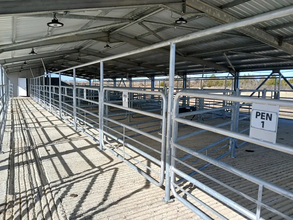 Covered holding pens with galvanized gates, the first one marked Pen 1