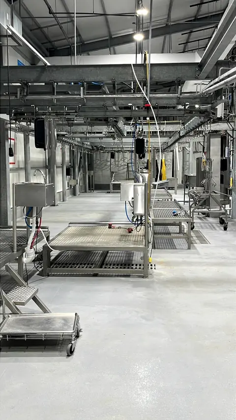 Overhead carcass rail running the length of the plant floor